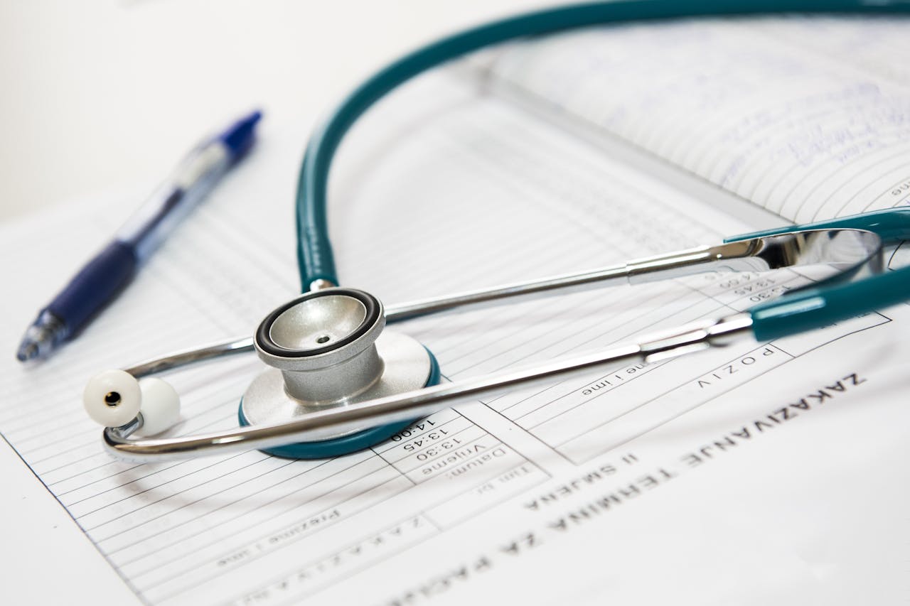 about-03 A stethoscope and pen resting on a medical report in a healthcare setting.